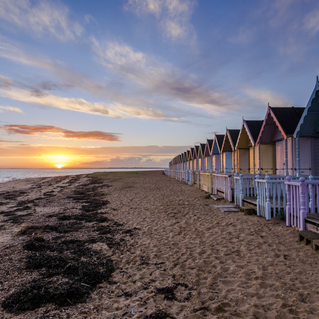 Beach huts at sunset on Mersea Island beach, Essex